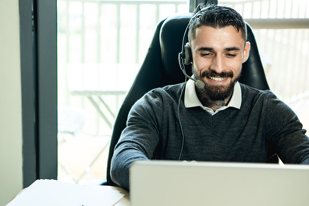bearded man wearing headphones while working in an office