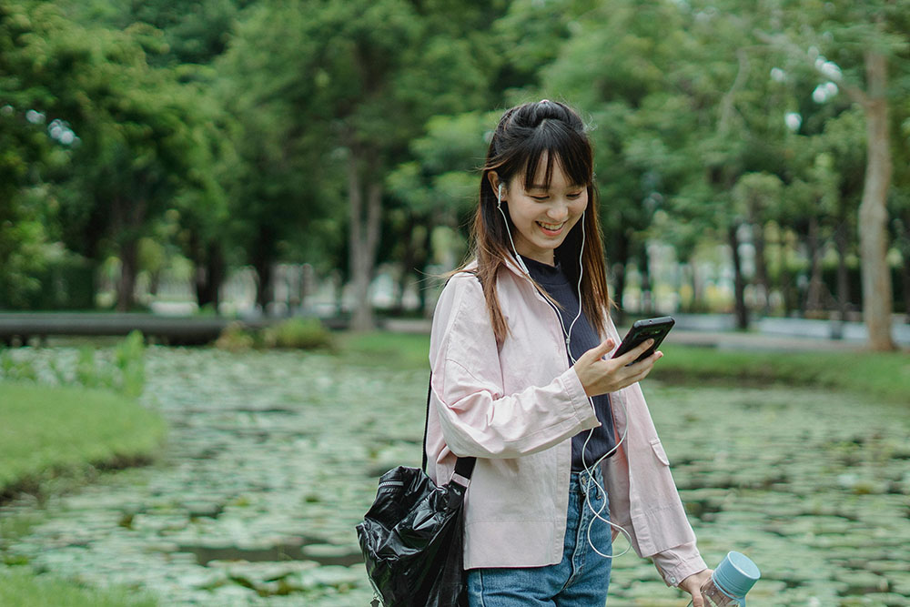 a woman smiling while using her phone