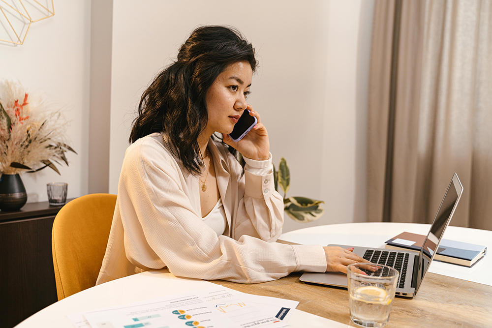 woman on a laptop while talking on the phone