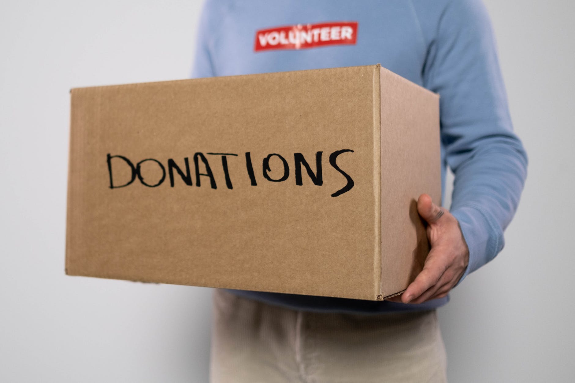 someone holding a box that says donations