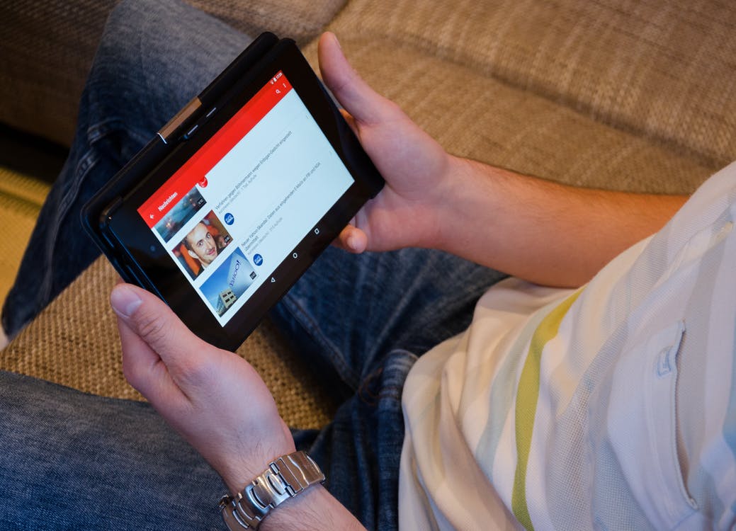 a man watching a youtube video on a tablet