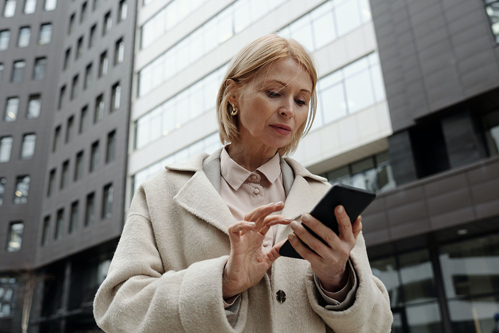 photo of a woman in a coat using her cell phone