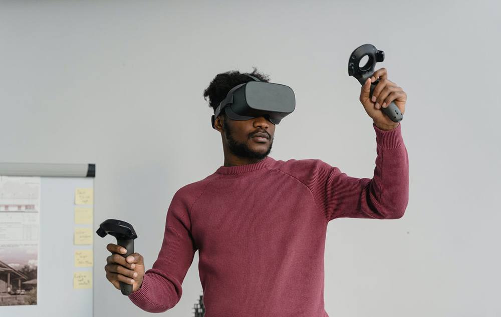 a man wearing a vr headset while also holding two controllers in his hands