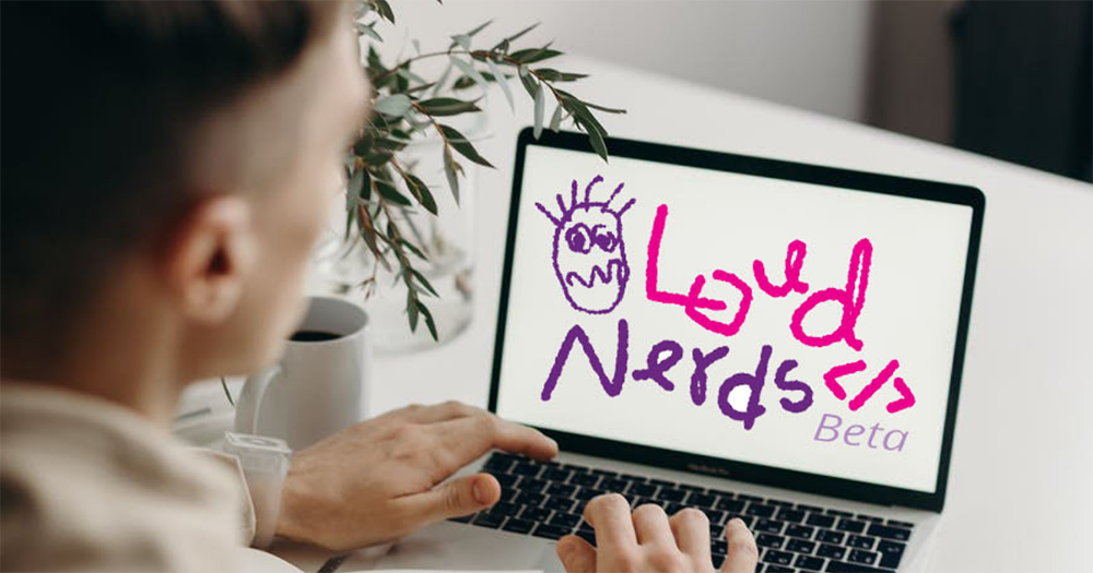 someone looking at a laptop that has the Loud Nerds logo on it