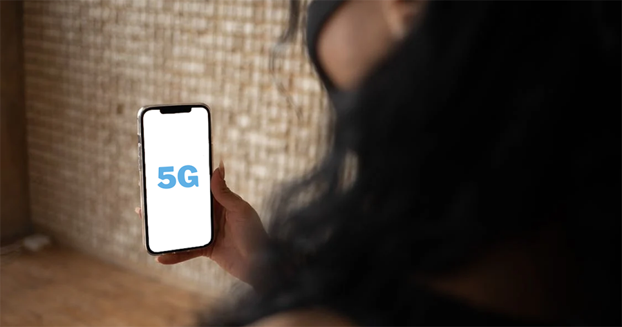 a woman holding a phone up that says 5g