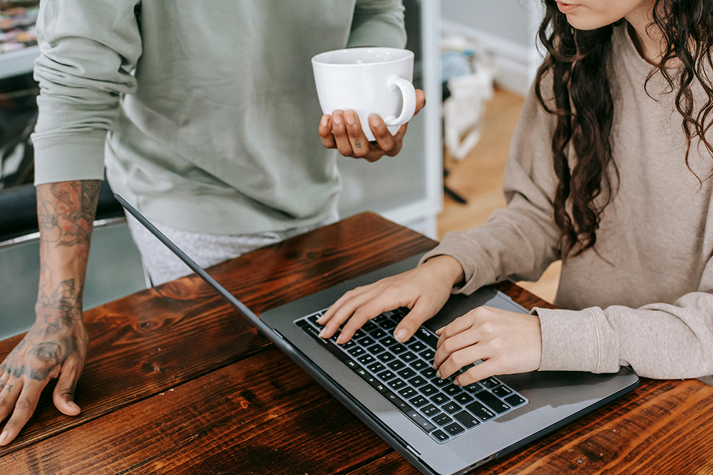 man helping woman with a laptop