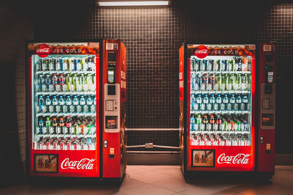 two coca cola vending machines placed next to each other